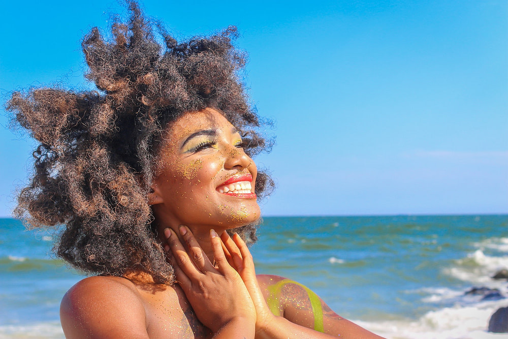 smiling happy woman with big hair at the beach